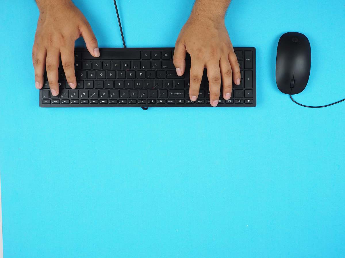computer hardware person holding black corded computer keyboard computer keyboard